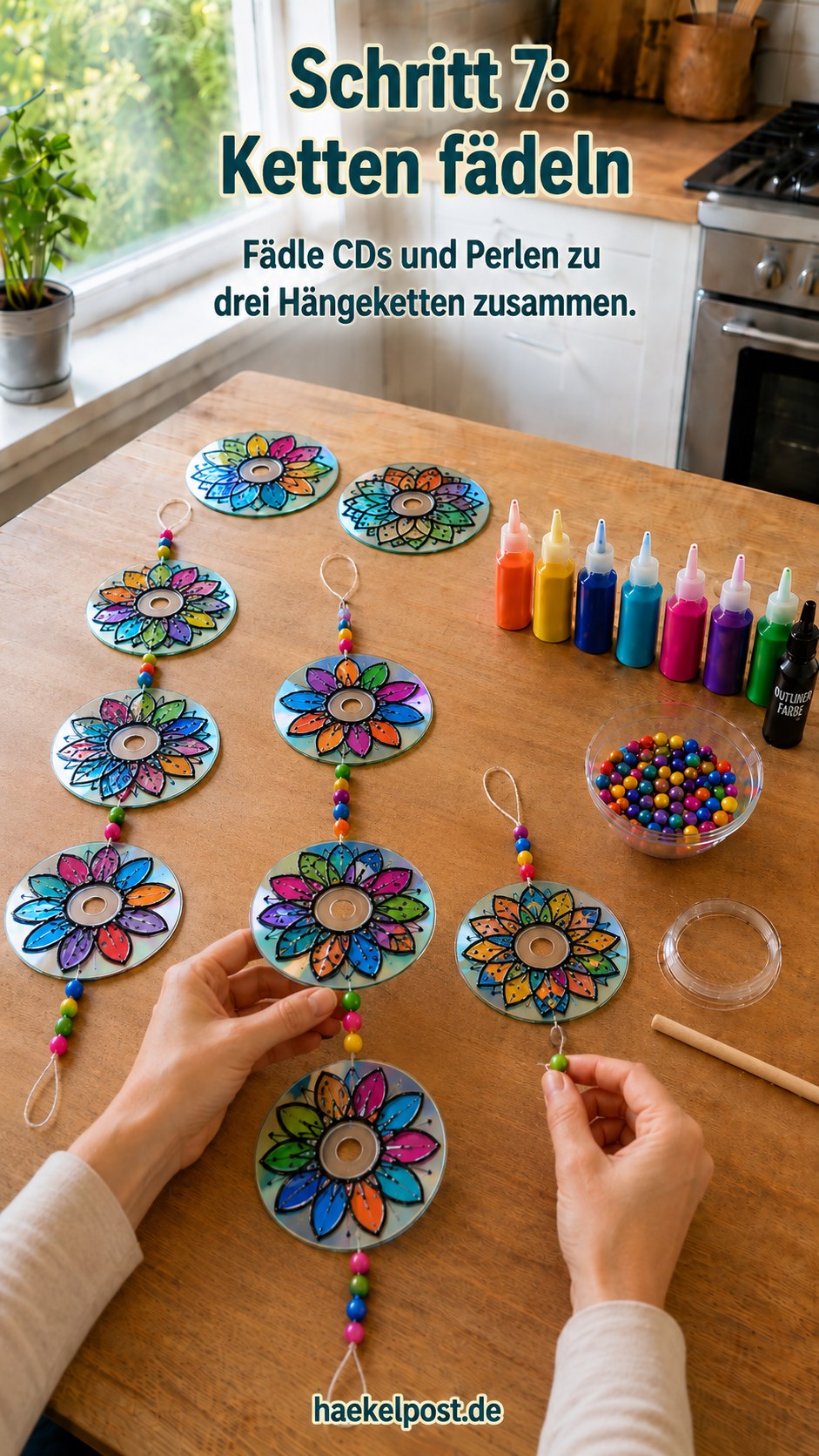 Drei Hängeketten aus bemalten CDs und Perlen werden für den Mandala-Sonnenfänger zusammengefädelt
